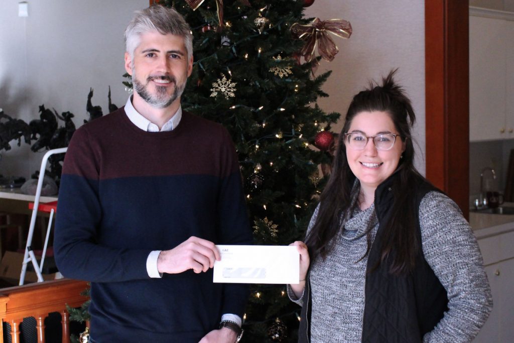 Pictured from left: GKT Attorney Christian Turak and WJMH Media teacher Carly McElhaney in front of Christmas tree decorated with red bulbs and white lights.