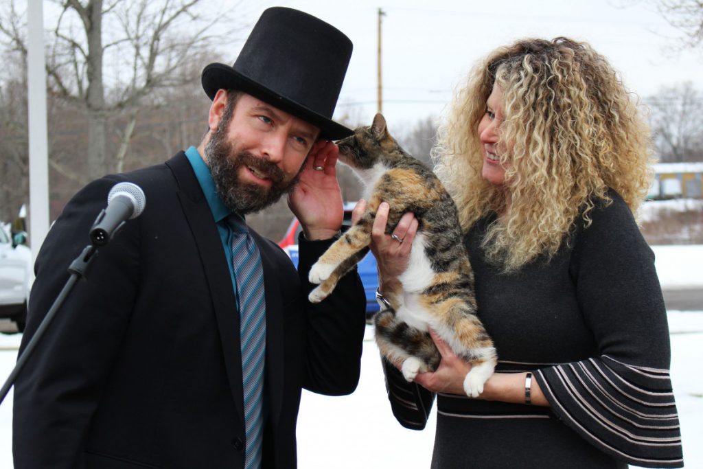 From left: WLES PE teacher Michael Grimm gets Wildcat Wally’s prediction whispered to him while WLES Speech Therapist Becky Hinerman holds the cat to his ear. 