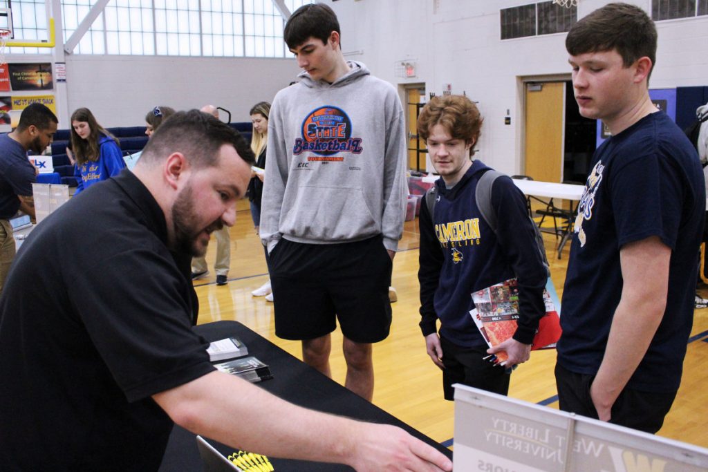 Pictured from left: WLU Admissions Counselor Aaron Kuhn explains to CHS senior Trevor Beresford, CHS junior Isaiah Bryan and CHS senior Nathan Haeberle what programs are offered by the Hilltoppers.