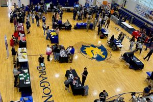 aerial view of tables and perople walking around the Cameron High School gymnasium at the fair.
