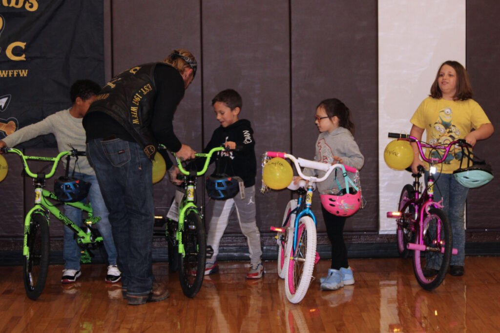 Kids and Warlords Motorcycle Club members with the new bikes.