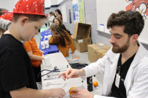 An ER doctor shows a student how to give someone stitches by using an orange.