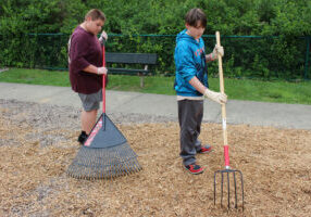 Students spread mulch at Grand Vue's playground.
