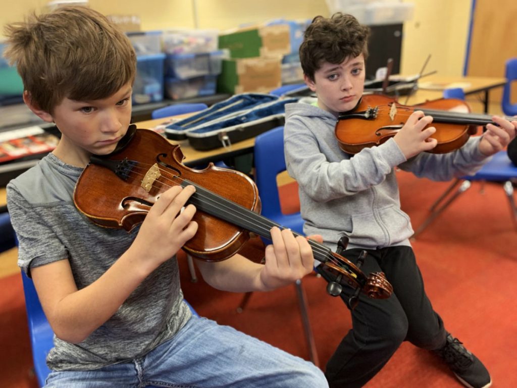 Hilltop Elementary fourth grade students David Carter and Hayden Cross rehearse for the upcoming Strings Winter Concert during class.