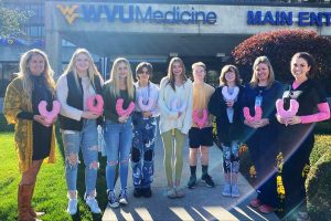 Holly Pettit, her students and WVU Medicine-Wheeling Hospital officials hold the mastectomy pillows in front of the hospital.