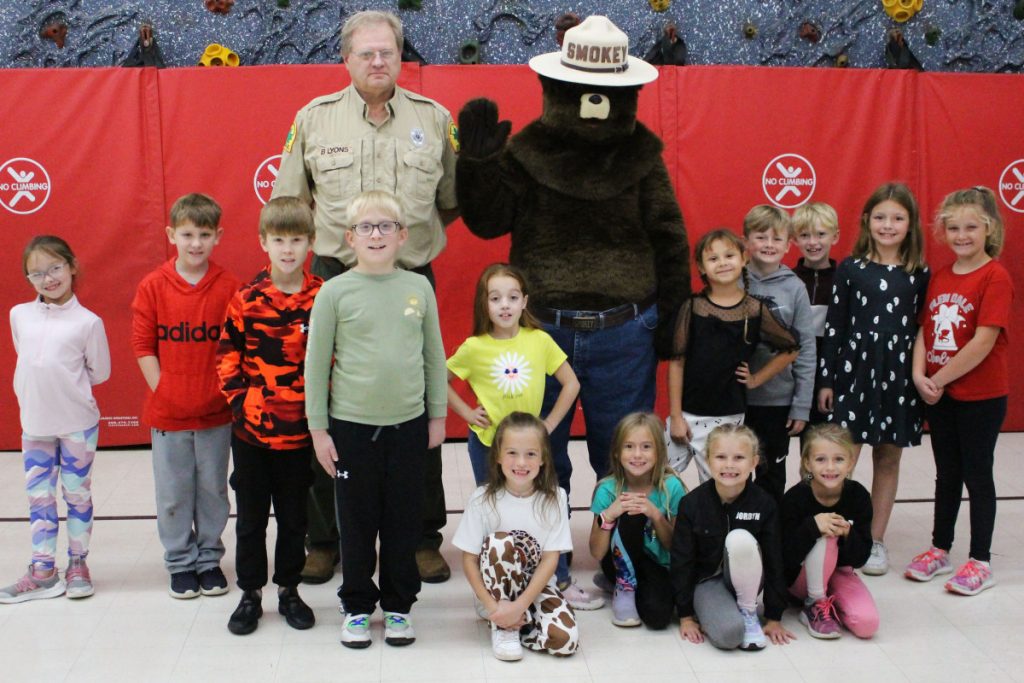 Tami Scollick’s second grade students are pictured with Brent Lyons, Service Forester, and Smokey Bear.