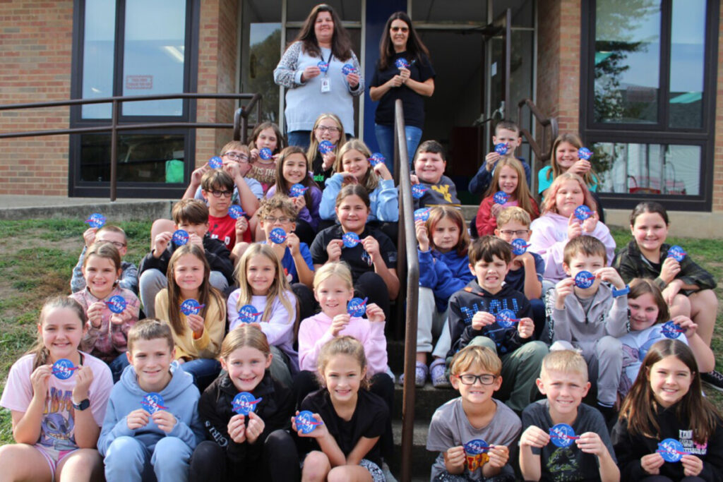 Seated are the 4th graders in Sherry Loy’s and Kim. Wood’s classes at GDES. They are holding the NASA patch given to them following the presentation. Standing, from left, are Loy and her sister, Lorie Massie Keller.