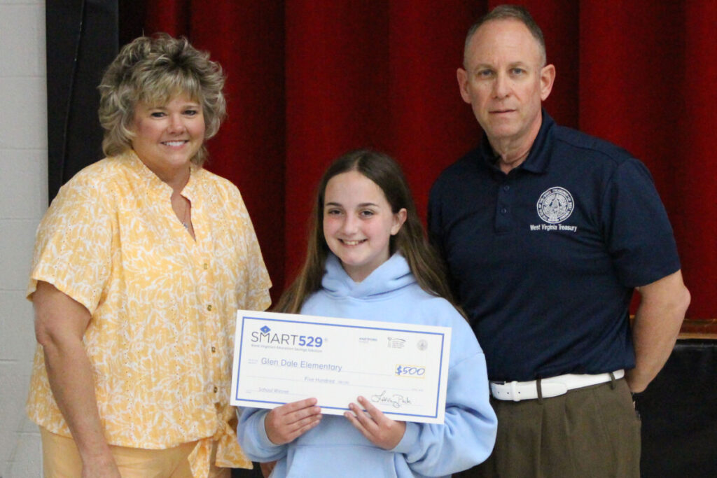 Pictured from left: Glen Dale Elementary Principal Kimberly Cain, Gabby Dantrassy and WV State Treasurer Regional Representative Tim Hooper. Gabby is holding the $500 check presented to her school in her honor. She will receive her $500 investment into a SMART529 college savings account in September. 