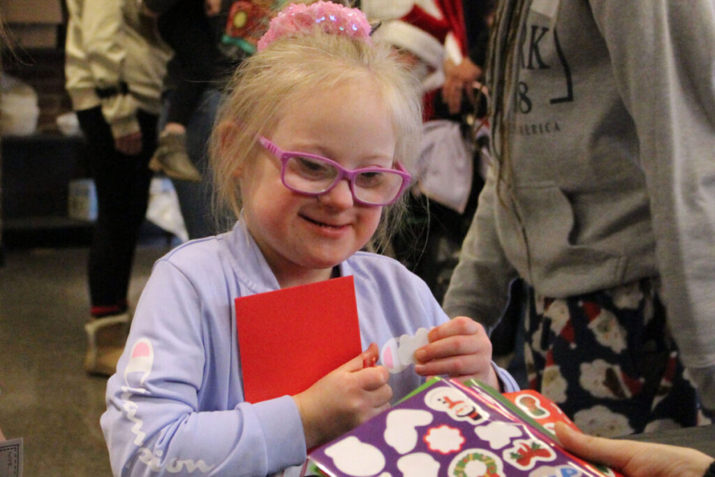 Cameron Elementary student Trinity Foster picks out her favorite holiday stickers to put on the Polar Express craft she is making.