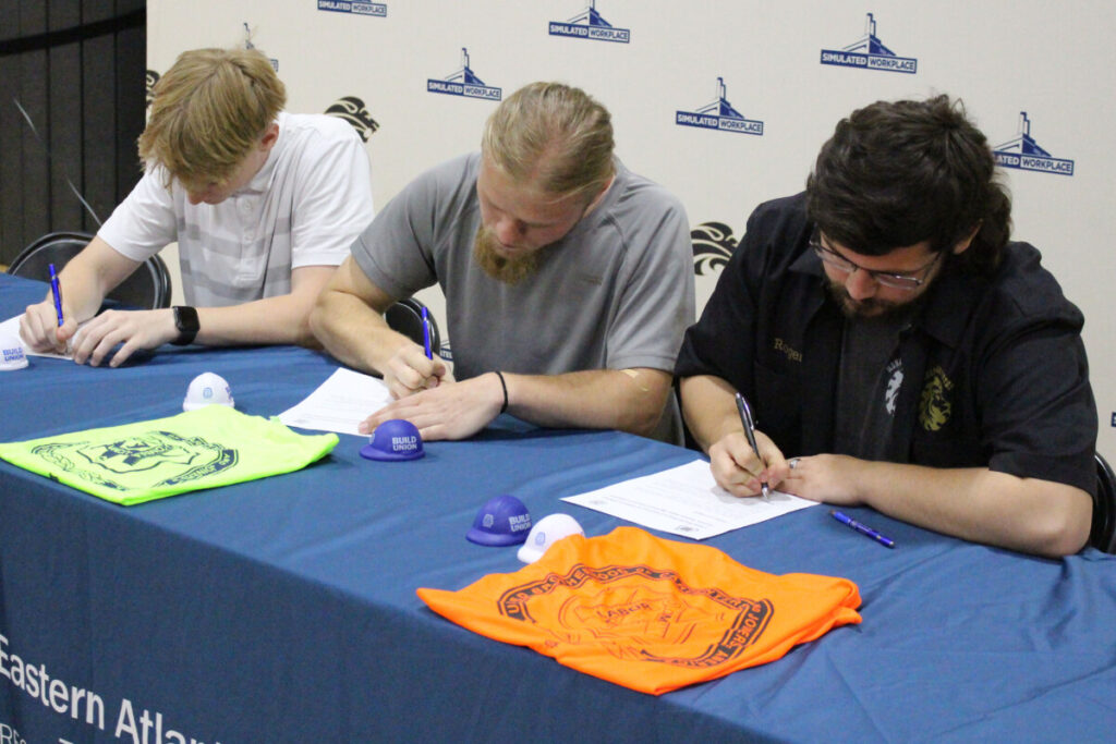 Seated, from left, are Landen Nelson, Jude Kesner-Rankin and Joseph Rogers signing their letters of intent.
