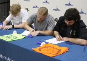 Seated, from left, are Landen Nelson, Jude Kesner-Rankin and Joseph Rogers signing their letters of intent.
