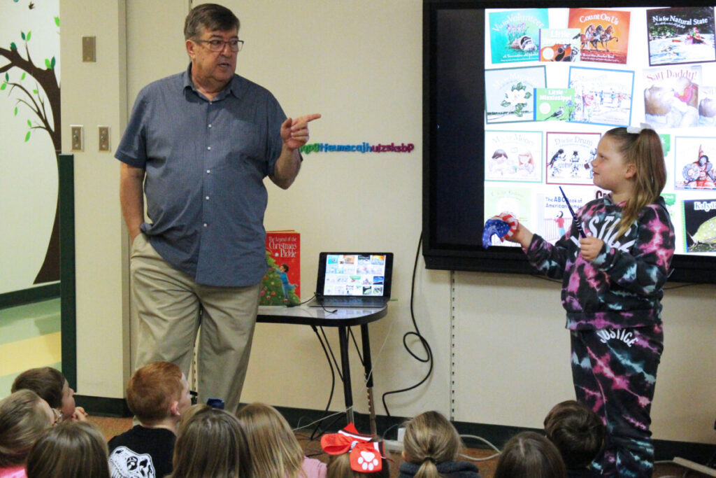 Mike Shoulders and McNinch Primary student Alivia Wood perform a magic trick beacuse Shoulders says, "Reading is magic."