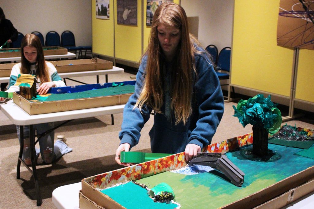 Pictured from left: MMS 8th graders Danielle Waldrop and Lyndee Bare put the final touches on their designs for the Marble Golf Course exhibit at the Mound Museum. 