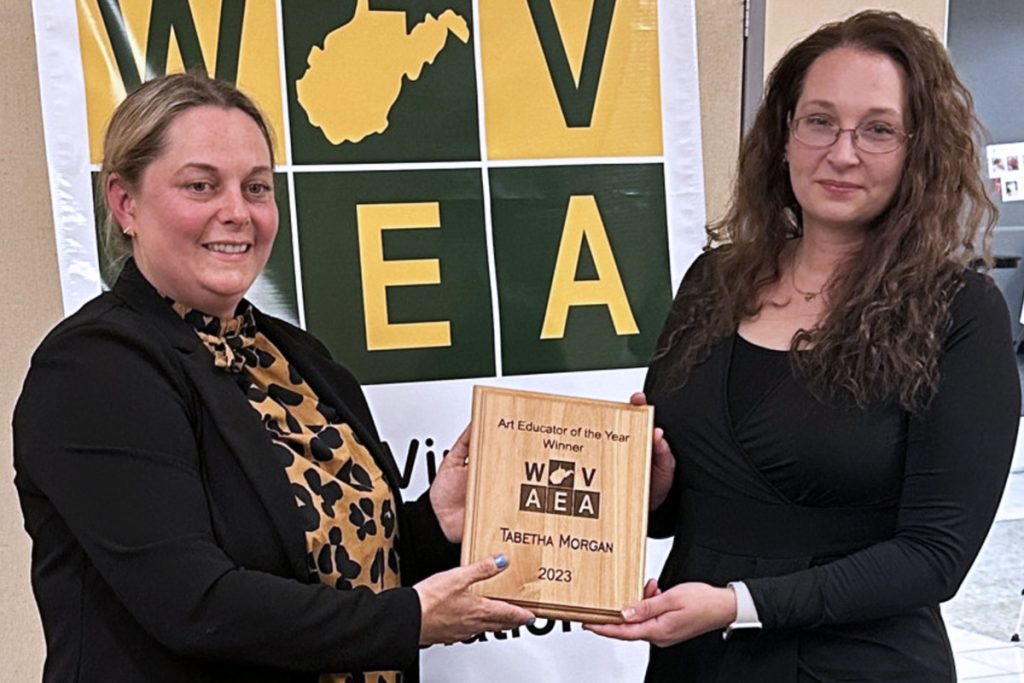 Pictured from left: WVAEA Vice President Tessa Garver presents MMS Art teacher Tabetha Morgan with her Art Educator of the Year plaque at the annual awards banquet.